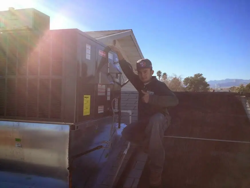 HVAC technician performing Boiler Repair on a rooftop unit in San Antonio